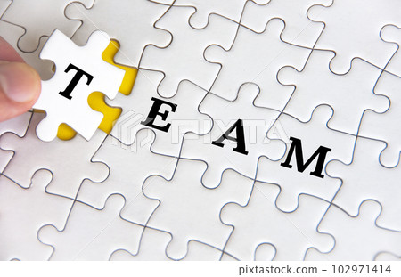 Team text on white jigsaw puzzle. Business and teamwork concept 102971414