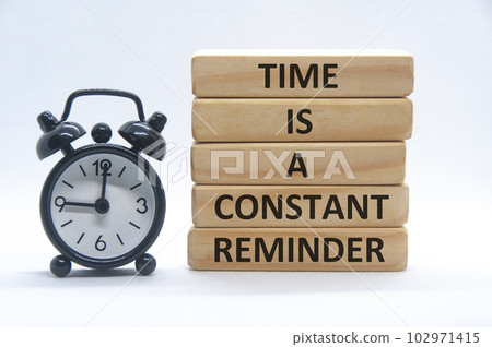 Time is a constant reminder text on wooden blocks with alarm clock on white background 102971415