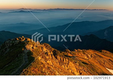 Mountain range of the Northern Alps at dawn seen from Mt. Senjogatake in the Southern Alps 102971913