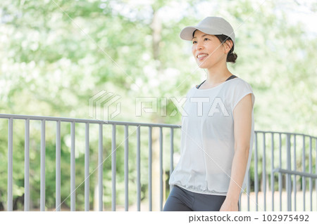 穿著運動服走路的微笑亞洲女人 102975492