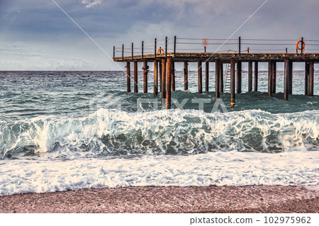 Storm in the Mediterranean Sea, Turkey, strong waves near the old wooden pier 102975962