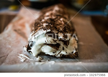 traditional Christmas dessert whole chocolate roll with cream, decorated with chocolate traditional Christmas dessert whole chocolate roll with cream, decorated with chocolate 102975966