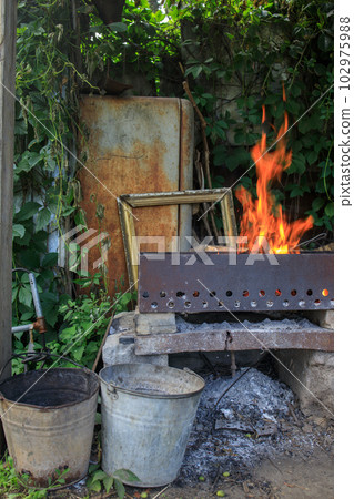 a fire in an old brazier in a dump of things 102975988
