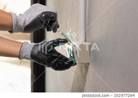 Electrician working safely on sockets of a residential electrical system 102977264