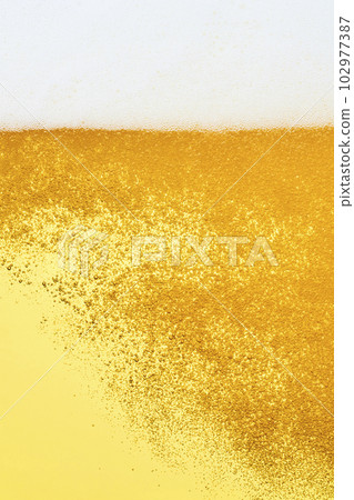 Draft beer poured into a glass, close-up 102977387