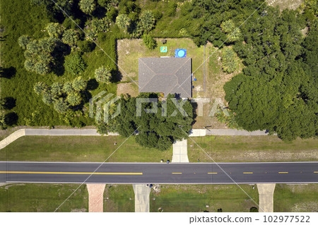 Aerial view of american small town in Florida with private homes between green palm trees and suburban streets in quiet residential area 102977522