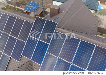 Aerial view building roof with rows of blue solar photovoltaic panels for producing clean ecological electric energy. Renewable electricity with zero emission concept Aerial view building roof with rows of blue solar photovoltaic panels for producing clean ecological electric energy. Renewable electricity with zero emission concept 102977637