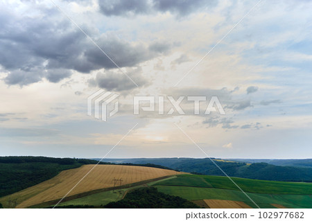 Aerial landscape view of green cultivated agricultural fields with growing crops on bright summer day 102977682