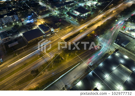 Above view of wide highway crossroads in Tampa, Florida at night with fast driving cars. USA transportation infrastructure concept 102977732