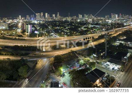 Above view of wide highway crossroads in Miami, Florida at night with fast driving cars. USA transportation infrastructure concept Above view of wide highway crossroads in Miami, Florida at night with fast driving cars. USA transportation infrastructure concept 102977735