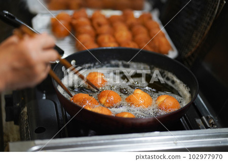 Woman making sata andagi 102977970