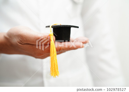 Asian woman doctor holding graduation hat in hospital, Medical education concept. 102978527