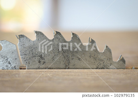 sharp metal saw on wood plank texture background, construction machine 102979135