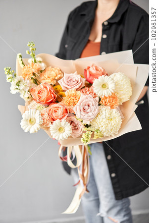 Beautiful bouquet of mixed flowers in woman hand. Floral shop concept . Beautiful fresh cut bouquet. Flowers delivery 102981357