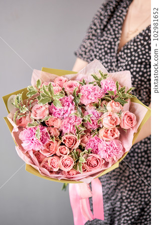 Beautiful bouquet of mixed flowers in woman hand. Floral shop concept . Beautiful fresh cut bouquet. Flowers delivery Beautiful bouquet of mixed flowers in woman hand. Floral shop concept . Beautiful fresh cut bouquet. Flowers delivery 102981652