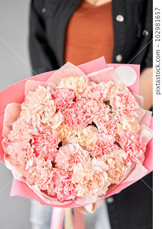 Beautiful mono bouquet of flowers in woman hand. Floral shop concept . Beautiful fresh cut bouquet. Flowers delivery Beautiful mono bouquet of flowers in woman hand. Floral shop concept . Beautiful fresh cut bouquet. Flowers delivery 102981657