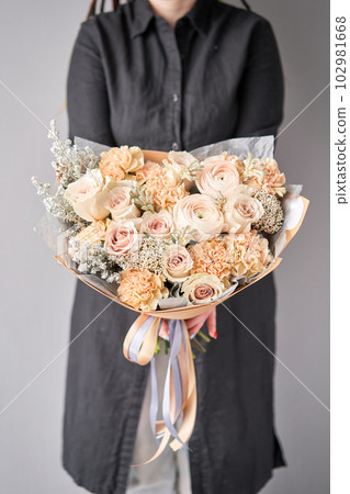 Beautiful bouquet of flowers in woman hand. Floral shop concept . Beautiful fresh cut bouquet. Flowers delivery 102981668