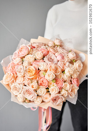 Peony-shaped roses. Beautiful large bouquet of flowers in woman hand. Floral shop concept . Beautiful fresh cut bouquet. Flowers delivery Peony-shaped roses. Beautiful large bouquet of flowers in woman hand. Floral shop concept . Beautiful fresh cut bouquet. Flowers delivery 102981670