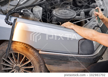 Removing dents on the car. PDR technology. Car body repair without painting. Removing dents on the car. PDR technology. Car body repair without painting. 102981702