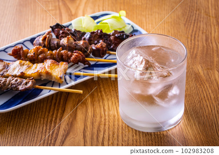 Assorted shochu on the rocks and yakitori 102983208