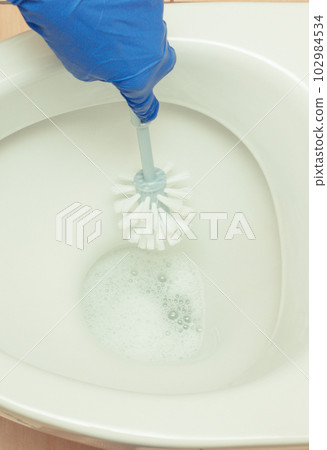 Hand of cleaner using brush for cleaning toilet. Household duties concept Hand of cleaner using brush for cleaning toilet. Household duties concept 102984534