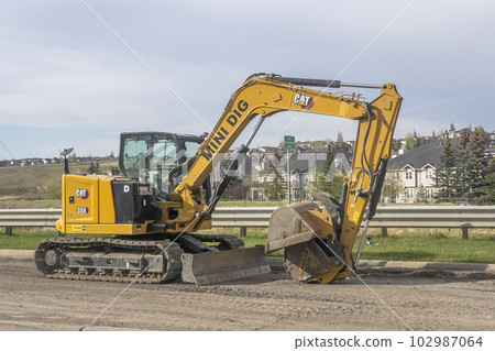Calgary, Alberta, Canada. May 11, 2023. An Excavator Digging Hole. Calgary, Alberta, Canada. May 11, 2023. An Excavator Digging Hole. 102987064