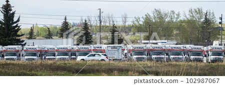 Calgary, Alberta, Canada. May 11, 2023. Front view panoramic of several U-Haul trucks parked in a storage facility. Calgary, Alberta, Canada. May 11, 2023. Front view panoramic of several U-Haul trucks parked in a storage facility. 102987067