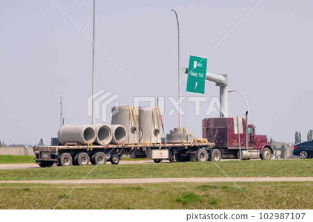 Calgary, Alberta, Canada. May 18, 2023. A trailer with a concrete cylinder pipe cargo. 102987107