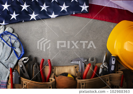 Tools hardhat toolbelt and us flag on concrete cement background labor day banner mockup 102988363