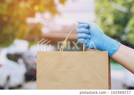 parcel delivery man of a package through a service. and close up hand customer female accepting a delivery of boxes from delivery man postal send direct to home. parcel delivery man of a package through a service. and close up hand customer female accepting a delivery of boxes from delivery man postal send direct to home. 102989257