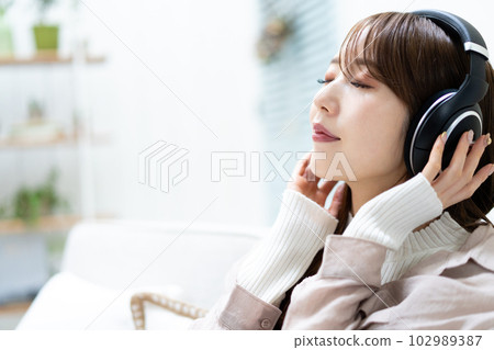 坐沙發和聽到音樂的婦女 102989387