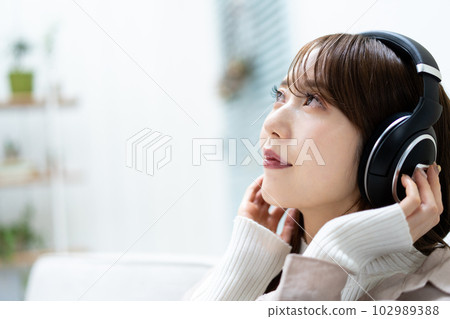 坐沙發和聽到音樂的婦女 102989388
