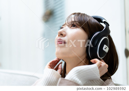 坐沙發和聽到音樂的婦女 坐沙發和聽到音樂的婦女 102989392