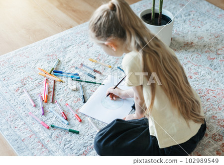 Child girl drawing with colorful pencils 102989549