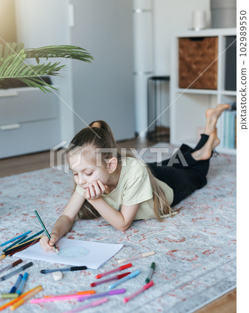 Child girl drawing with colorful pencils 102989550