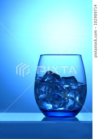 一個裝滿水的玻璃杯漂浮在藍色中 102989714