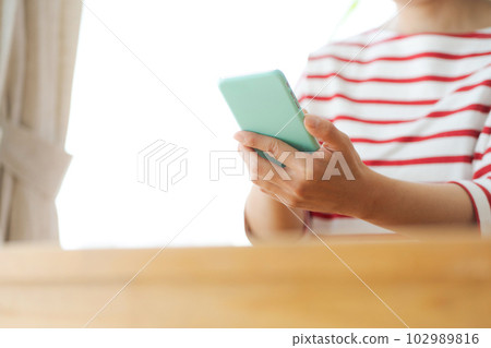 一個女人用智能手機的手剪 102989816