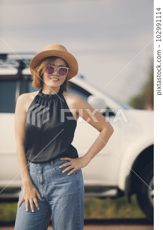 woman with straw hat toothy smiling with relaxing standing outdoor against suv car background woman with straw hat toothy smiling with relaxing standing outdoor against suv car background 102991114
