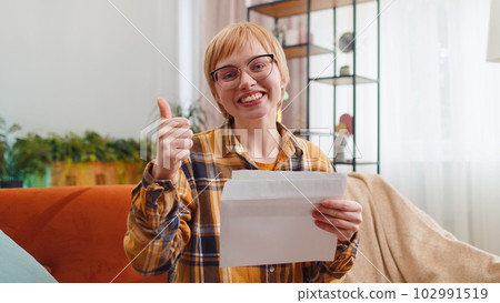 Woman open envelope letter reads it feel happy, career growth advance promotion, bank loan approve 102991519