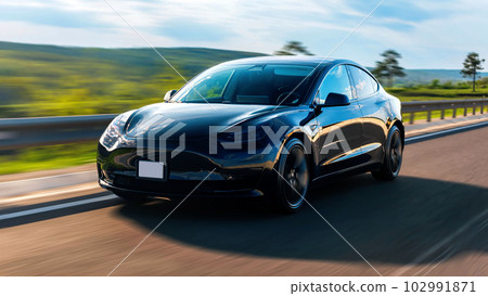 Front view of a moving black car on a highway 102991871