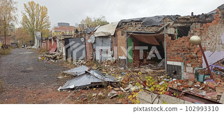Destruction in wall of multi-storey building after being hit by artillery shell Destruction in wall of multi-storey building after being hit by artillery shell 102993310