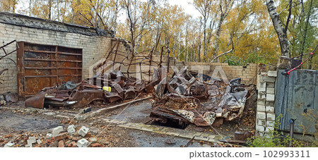 Burnt cars in destroyed garages during war in Ukraine. Destroyed cars Burnt cars in destroyed garages during war in Ukraine. Destroyed cars 102993311
