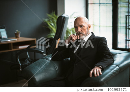 Sad mature man dressed in suit, sitting in chair, deep in thought. Essence of his introspection and contemplation, highlighting his profound wisdom and business acumen. . High quality photo Sad mature man dressed in suit, sitting in chair, deep in thought. Essence of his introspection and contemplation, highlighting his profound wisdom and business acumen. . High quality photo 102993371