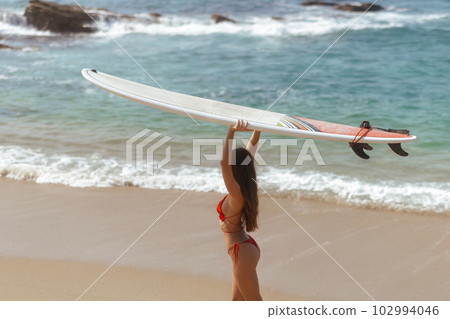 Surfer Woman with Surfboard in Tropical Paradise During Summer Sea Vacations Surfer Woman with Surfboard in Tropical Paradise During Summer Sea Vacations 102994046