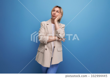 close-up of a pensive blonde business woman in a jacket on a background with copy space close-up of a pensive blonde business woman in a jacket on a background with copy space 102994445