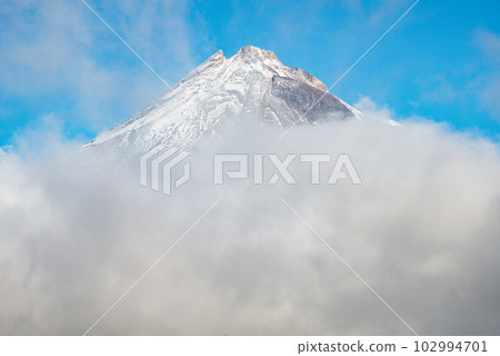 The scenery view of Mt.Taranaki (Mount Egmont) behind the clouds. This mountain is one of the popular volcano in Western region of North Island, New Plymouth, New Zealand. 102994701