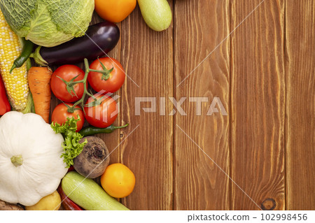 Top view of various vegetables on a wooden table with copy space. Top view of various vegetables on a wooden table with copy space. 102998456