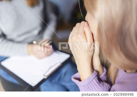 Psychotherapy session, a woman is talking with her psychologist at her office 102998496