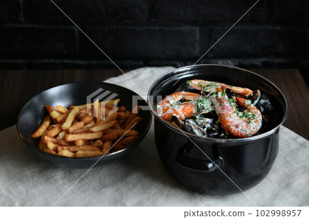 Mussels with sauce and shrimps and french fries 102998957