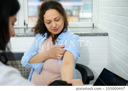 Pregnant woman visits obstetrician-gynecologist for regular check-up during pregnancy in gynecological clinic. Blood pressure measurement to prevent eclampsia. Pregnancy-induced Hypertension concept 103000447